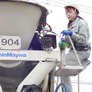 トミキサー車で生コンクリートを流し込む女性ドライバー