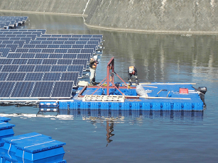 フロート式水上太陽光発電システムのユニットを連結する作業員
